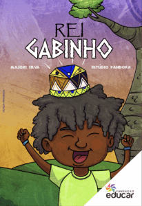 Capa ilustrada do livro Rei Gabinho. A imagem mostra um menino negro sorridente. Ele tem cabelos volumosos e crespos, e usa uma camiseta verde clara. Sobre sua cabeça, há uma coroa colorida com formas geométricas. Ao fundo, vê-se um céu em tons de roxo e laranja, uma grande árvore e colinas verdes. No topo da capa, está escrito “Rei Gabinho” na cor branca. Abaixo do título, o nome da autora: Majori Silva e do ilustrador: Estúdio Pandora. No canto inferior direito, está o logotipo multicolorido da Fundação Educar.